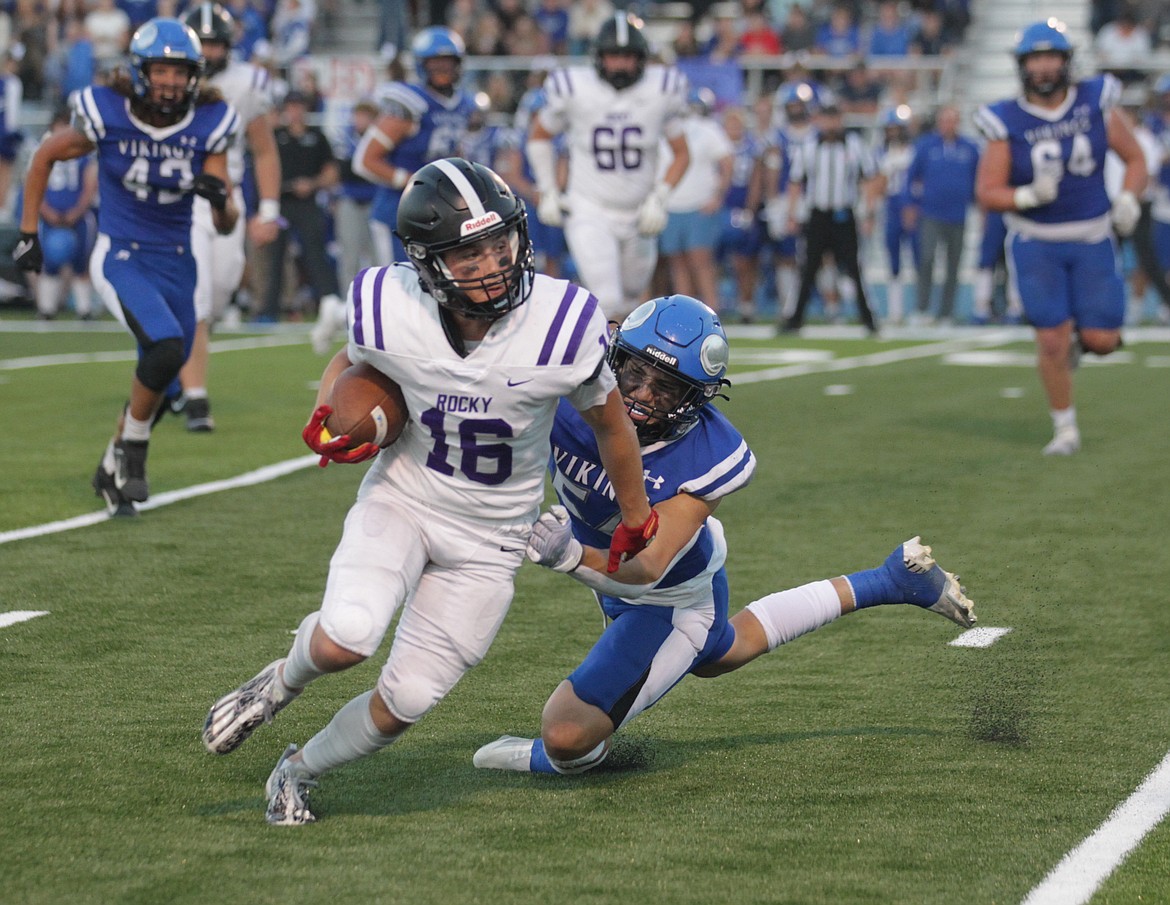 Alex Brown, right, of Coeur d'Alene tries to drag down Jeff Thompson of Rocky Mountain on Friday night at Viking Field.