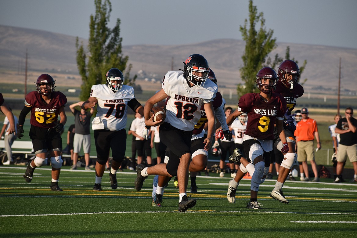 Ephrata sophomore Brady Hendrick (12) carries the ball against the Moses Lake defense at Friday’s Jamboree in Quincy.