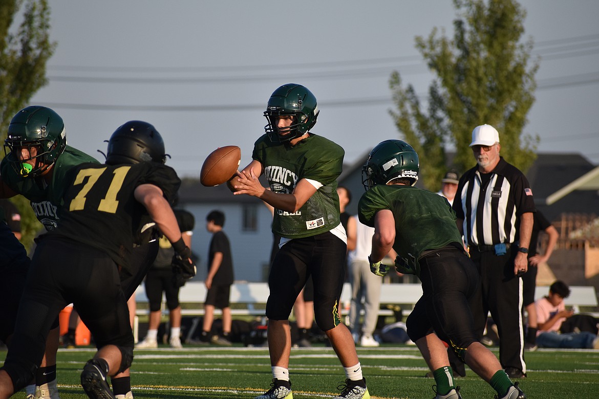 The Quincy offense begins a play against the Royal defense at Friday’s jamboree at Quincy High School.