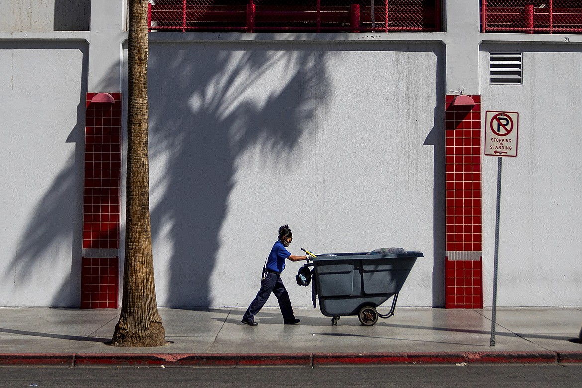 A maintenance worker pushes a refuse cart in the sun, Friday, Aug. 25, 2023, in Las Vegas. A historic heat wave that began blasting the Southwest and other parts of the country this summer is shining a spotlight on one of the harshest, yet least-addressed, effects of climate change in the U.S.: the rising deaths and injuries of people who work in extreme heat, whether inside hot warehouses and kitchens or outside under the blazing sun. Many of them are migrants in low-wage jobs. (AP Photo/Ty O'Neil)