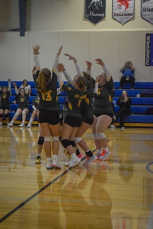 Members of the St. Regis Lady Tigers volleyball team celebrate a point during the season opening match with Seeley in St. Regis Friday night.  (Photo by Rylie Burnham)