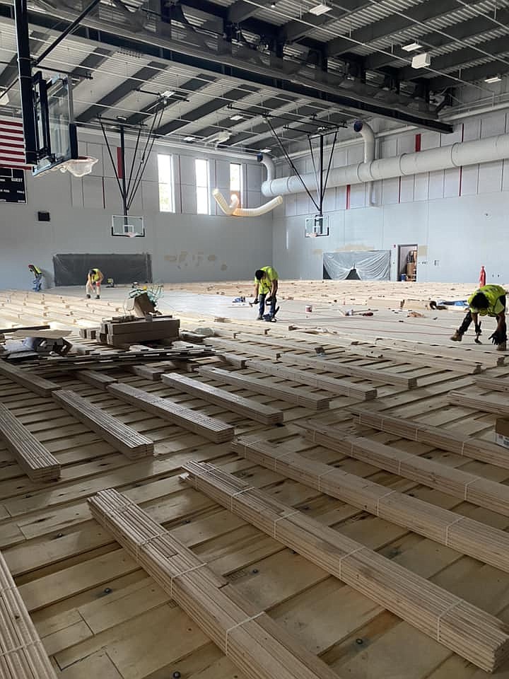 Construction workers install the floor in the new Almira school gym. The new building replaces one destroyed by fire in October 2021.