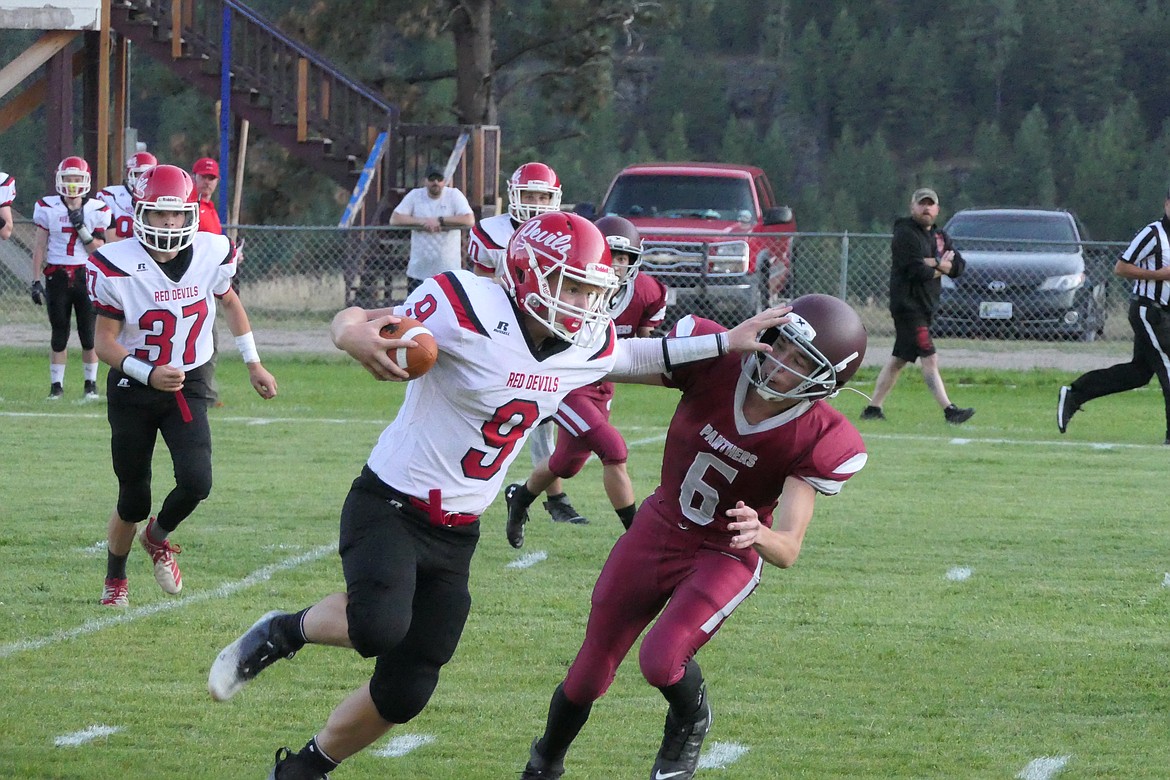 Noxon senior quarterback Shamus Wheeldon (9) stiff-arms Alberton sophomore Camden Notley out of the way on this first quarter touchdown run in the first quarter of Noxon's win over Alberton Friday night in Alberton.  (Chuck Bandel/MI-VP)