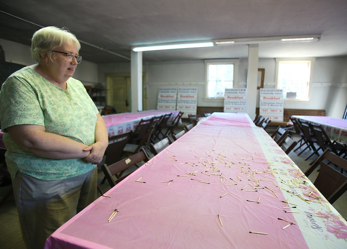 Pleasantview Community Association member Cindy Mead looks over a mess of matches Monday in the old Pleasantview School in Post Falls. The matches and other evidence of someone lighting fires in the historical building were discovered Aug. 16.