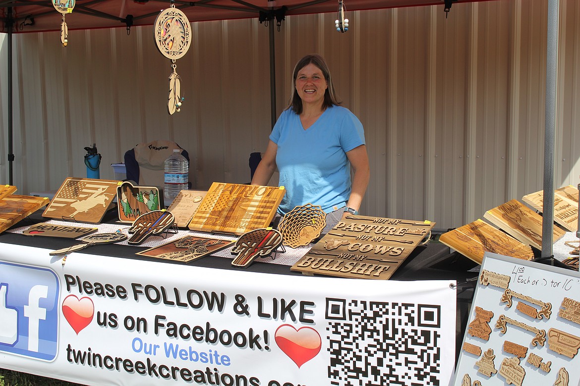 Janet Hughes staffs the Second Creek Creations booth recently and will be at the Superior Farmers Market on Saturday mornings. The business was started by Janet and her husband, Charles, who add a unique flare to laser engraved woods, glass and slate. They have resided in DeBorgia for about 10 years and this business was to be for their retirement, but they started early. (Monte Turner/Mineral Independent)