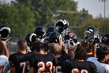 Ephrata players hold their helmets in the air at the end of a Tiger practice on Aug. 24. The Tigers open the season on the road against Moses Lake on Friday.