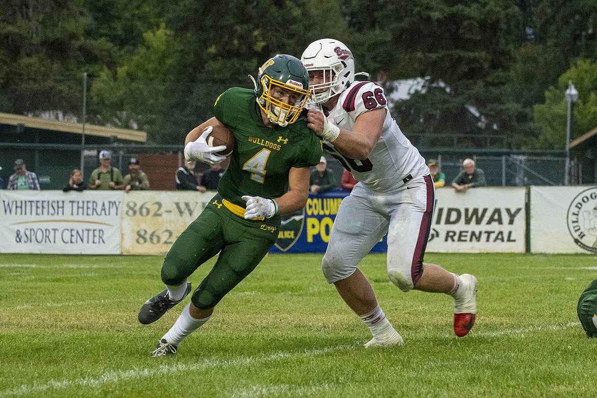 Whitefish's Dane Hunt faces a tackle from Andrew Burrows in the Bulldogs’ first game of the season against Hamilton at Whitefish on Friday, Aug. 25. (Avery Howe/Hungry Horse News)