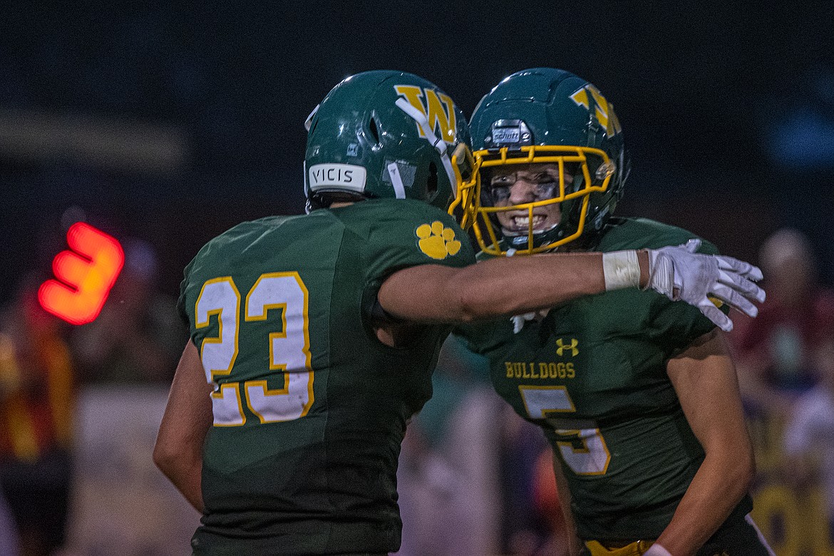 Cole Moses and Jesse Burrough celebrate a play in the Bulldogs’ first game of the season against Hamilton at Whitefish on Friday, Aug. 25. (Avery Howe/Hungry Horse News)