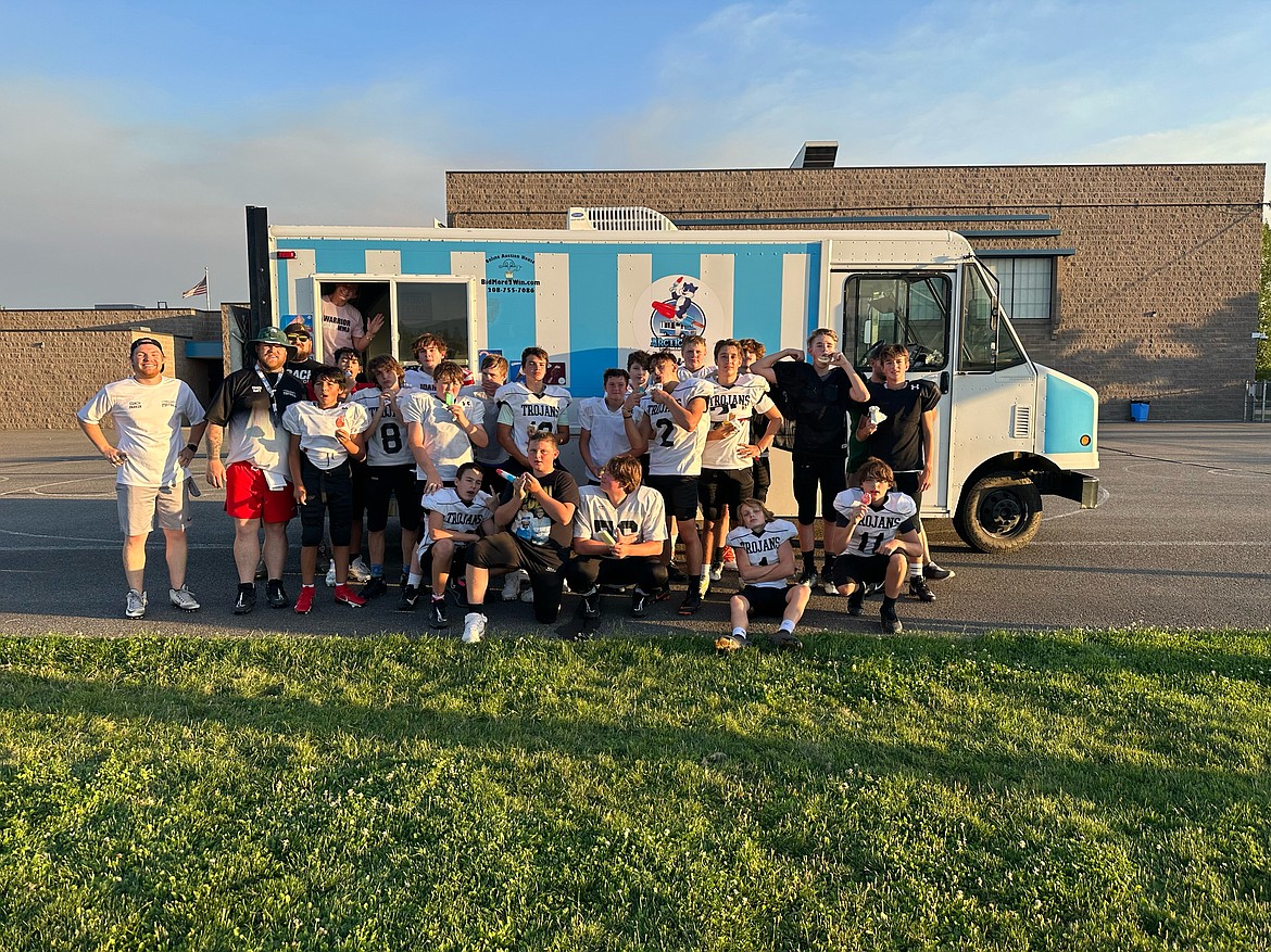 Courtesy photo
Members of the Post Falls Junior Tackle eighth grade team were treated recently to "ice cream truck day", thanks to the Post Falls Junior Tackle board, provided by Arctic Kat after a week of workouts in pads in the heat. "A lot of these guys went straight from last season, through offseason training with 'Strength Through Movement,' back into football and it has become a very dedicated mindset for the sport in the Post Falls area," head coach Matt Miracle said. "They're seeing the noise the high school has been making in the sport and are motivated to push that forward for years to come." Players, from left, include Jesiah Smith, Elijah Van Reenen, Nathyn George, Charlie Larsen, Nassin Smothers, Isaiah Lewis, Blayne Boyd, Jackson Holley, Darrin Tune, Jacob Wilson, Anthony Eastwood, Dominic Wilcox, Austin Schaad, AJ Spruill, Brody Reaves, Archer Kirk, Chris Reed, Joseph Hixson, Andy Cox and Chase Guilmette; and coaches from left, Parker Lewis (offensive coordinator), Matt Miracle (head coach) and Max Noll (line coach); and far right, Ronnie Ramirez (far right Defensive Coordinator).
