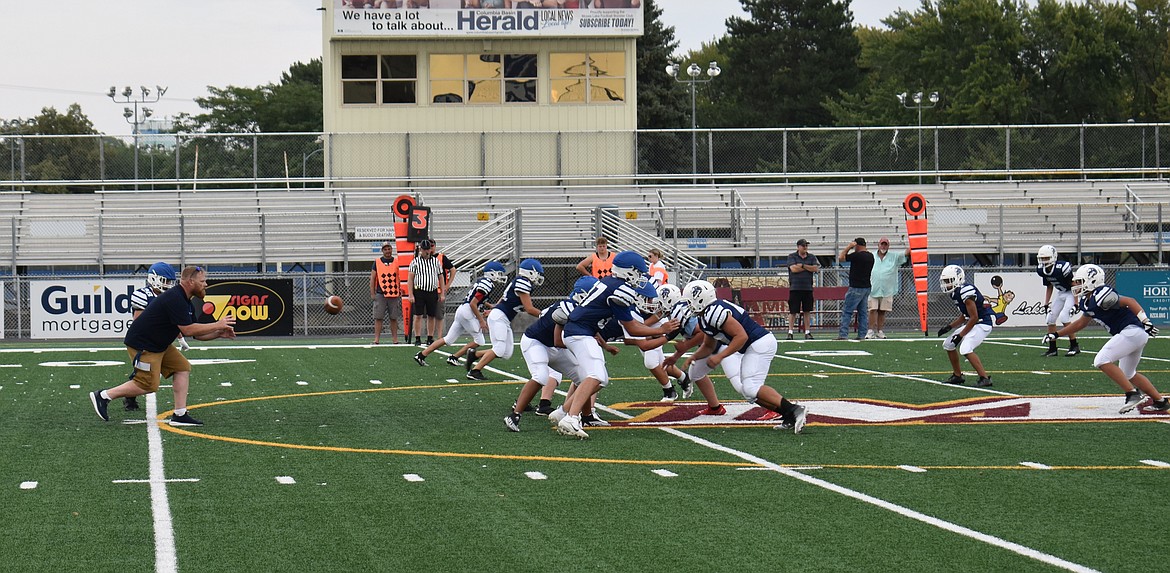 Moses Lake Christian Academy/Covenant Christian School Head Coach Aaron Noble catches a snap to show his team some passing techniques at practice Saturday.