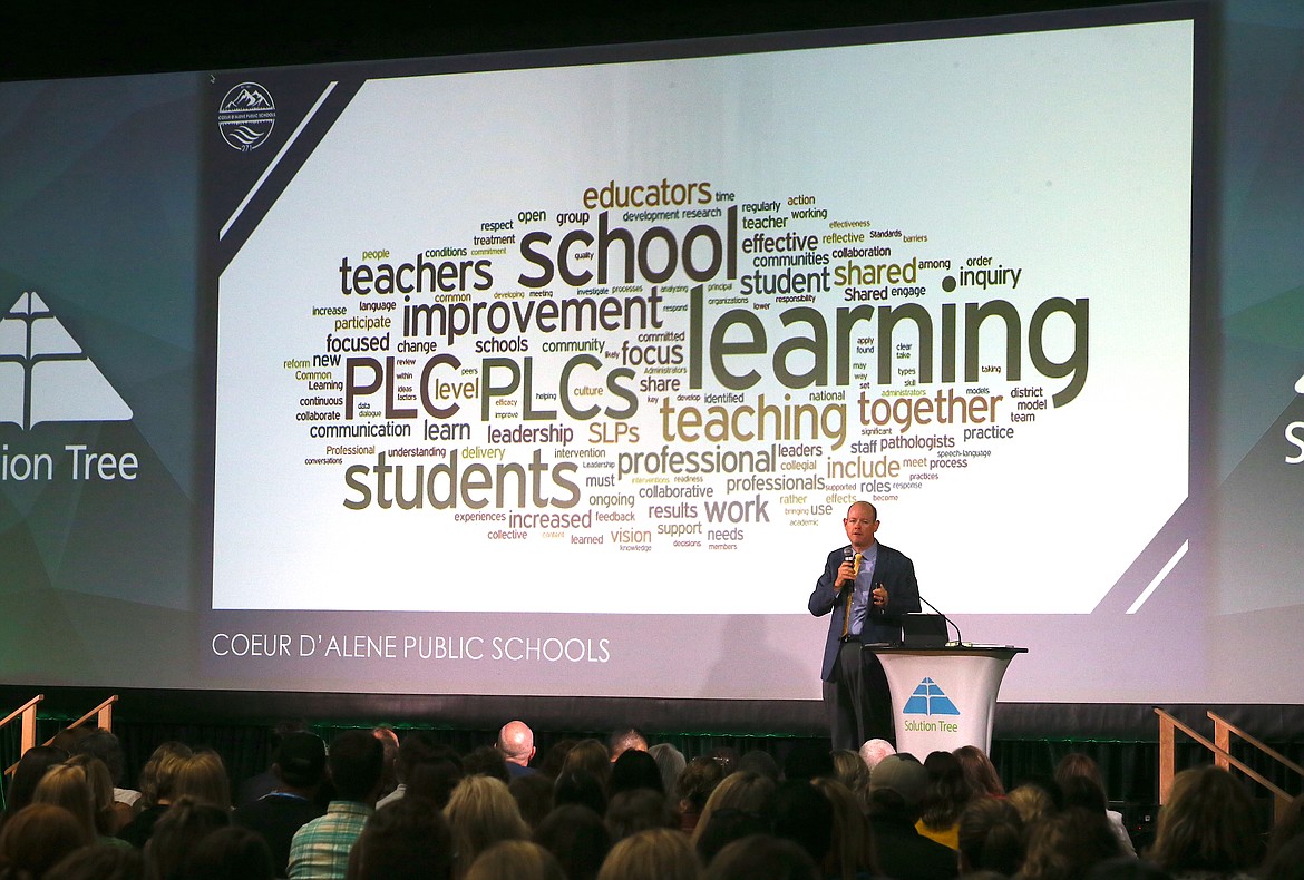 Coeur d'Alene Superintendent Shon Hocker stands in front of a word cloud filled with words educators have used to associate with professional learning communities as he welcomes everyone Tuesday morning to the Professional Learning Communities at Work conference at Lake City High.