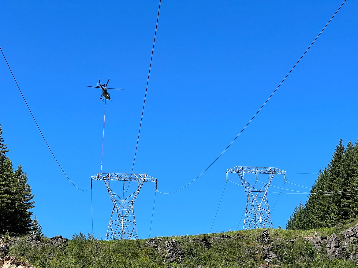 Bonneville Power Administration crews use a helicopter to replace an insulator. Damaged equipment is susceptible to sparking, which could lead to a fire, BPA officials said.