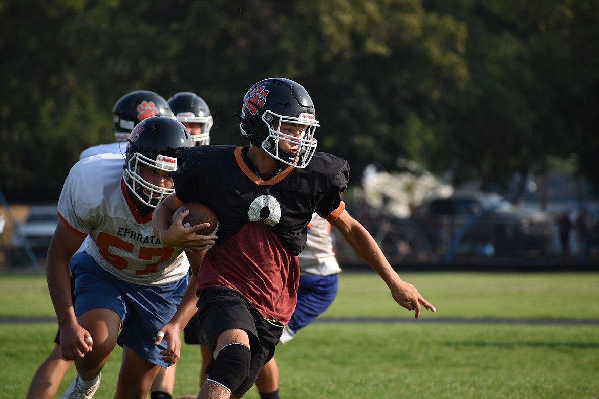 Ephrata senior Walker Fulk tucks the ball and runs against the Tiger defense during practice.