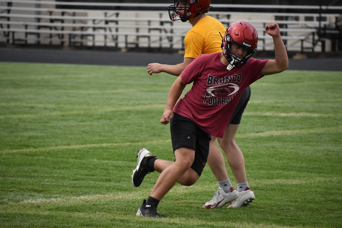 LRS senior Travis Redburn, in red, makes a move during a linebacker drill. Reburn is also taking over as quarterback for the Broncos this season.