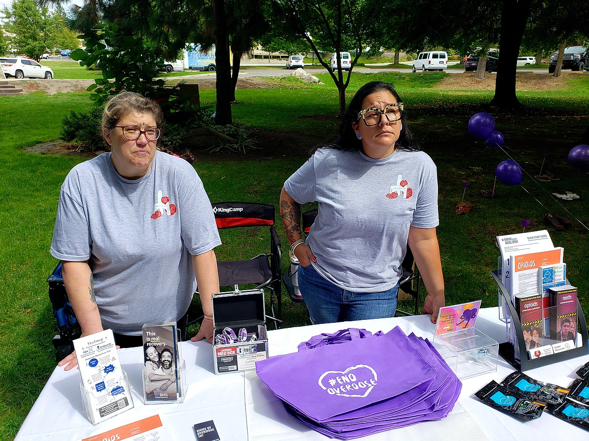 From Left, Bree Larosa and Roxann Esparza from North Idaho Alliance of Care gave out Narcan, key chains and information during an International Overdose Awareness Day memorial, where 381 pairs of shoes represented each of the 381 overdose deaths in Idaho in 2022.