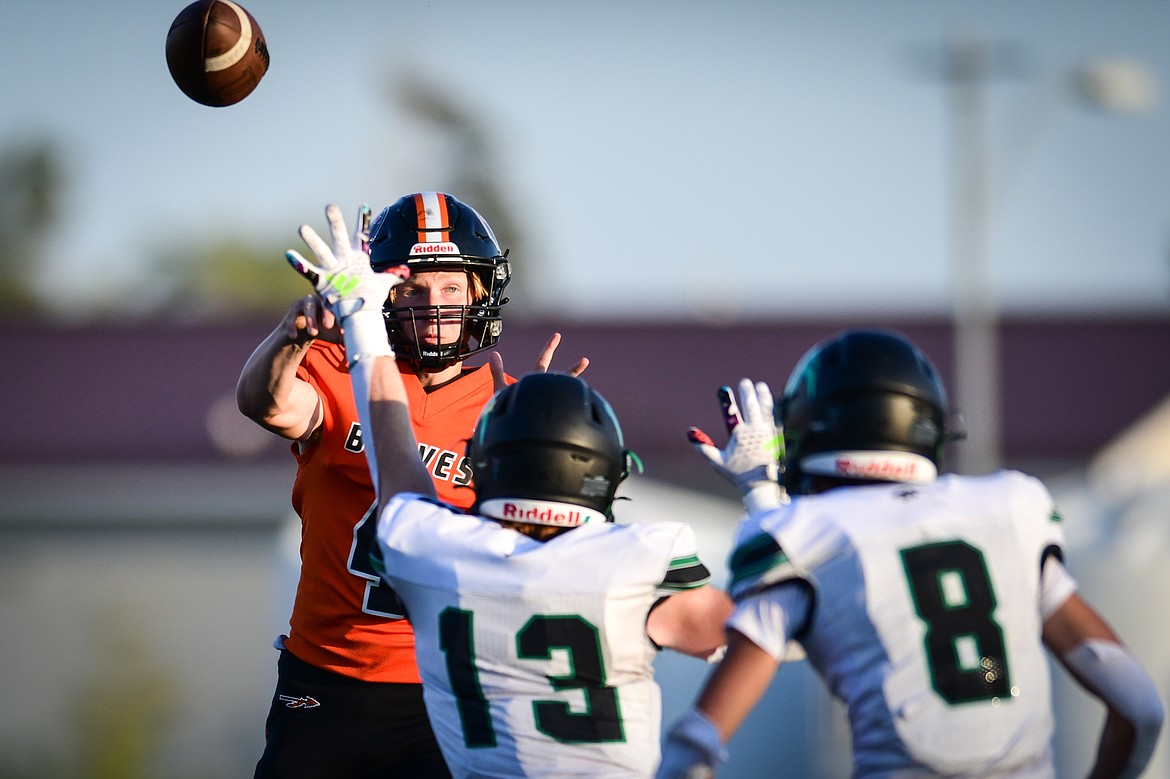 Flathead quarterback Brett Pesola (4) passes under pressure from a pair of Belgrade defenders in the first half at Legends Stadium on Friday, Sept. 1. (Casey Kreider/Daily Inter Lake)