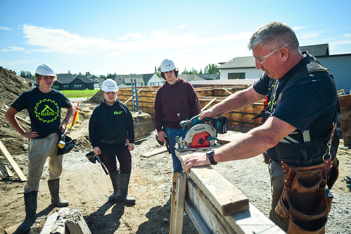 Kalispell Student Built Homes instructor Brock Anderson gives a demonstration on measuring and cutting at a home site build on Northridge Way in Kalispell on Friday, Sept. 1. (Casey Kreider/Daily Inter Lake)