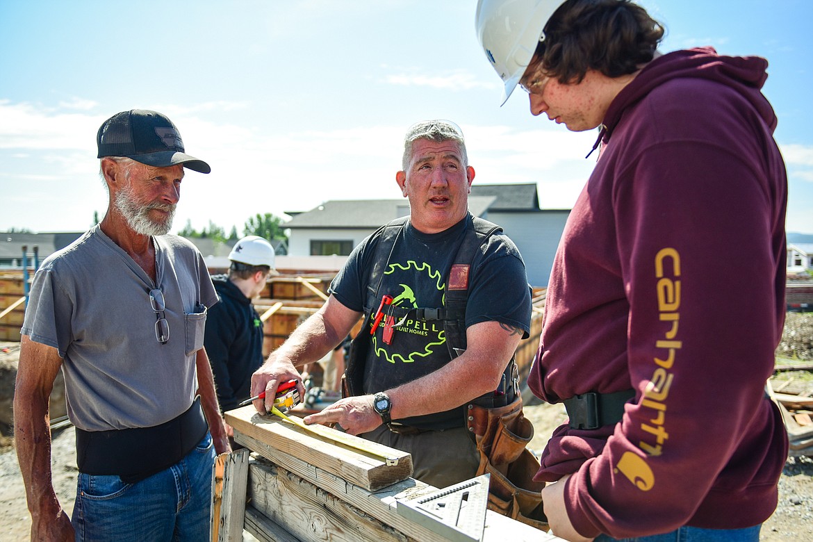 Kalispell Student Built Homes instructors Tim McLean, left, and Brock Anderson work with Glacier High School senior Stewart Ackroyd at a home site on Northridge Way in Kalispell on Friday, Sept. 1. (Casey Kreider/Daily Inter Lake)