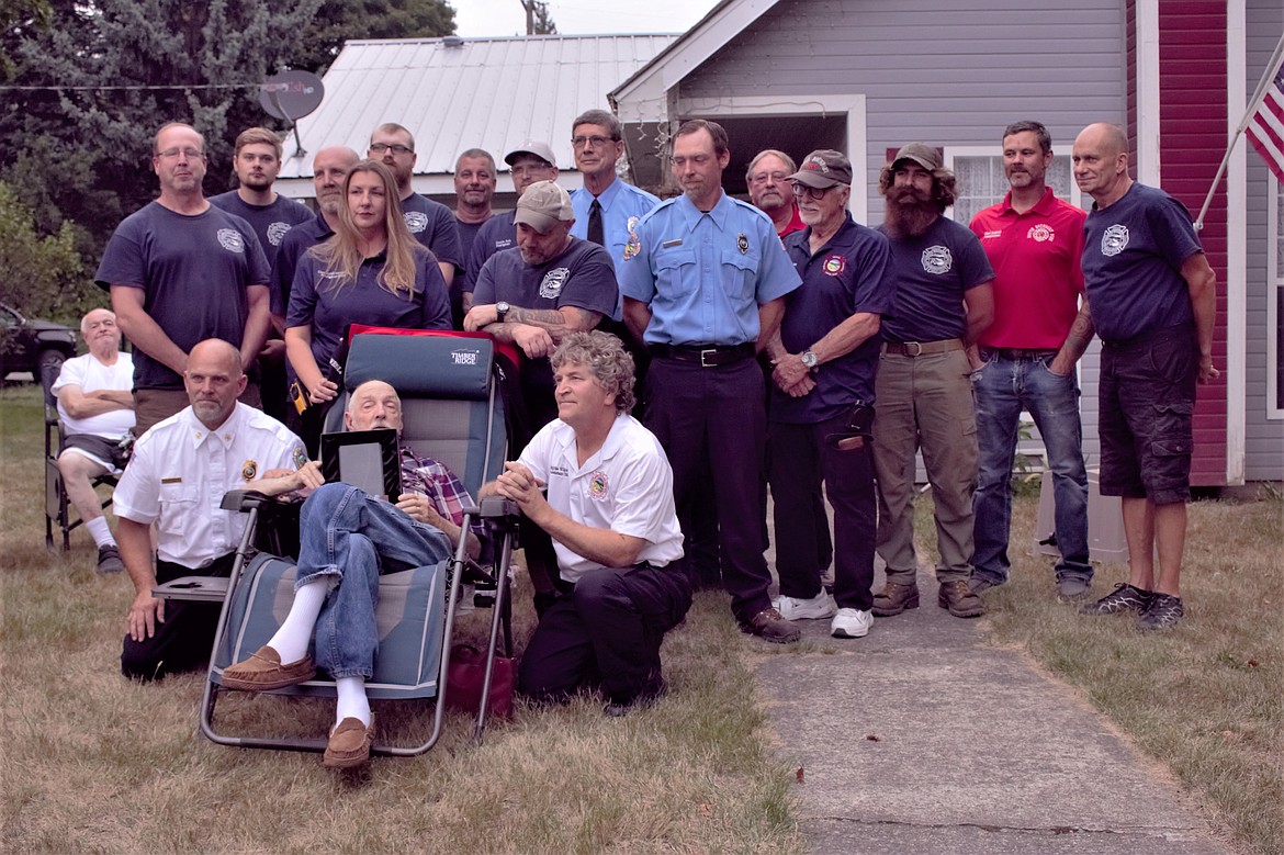 Wesley "Wes" Portrey (center) holds the Firefighter of the Century award surrounded by family and the South Boundary Fire Protection District volunteers, leadership and commissioners.