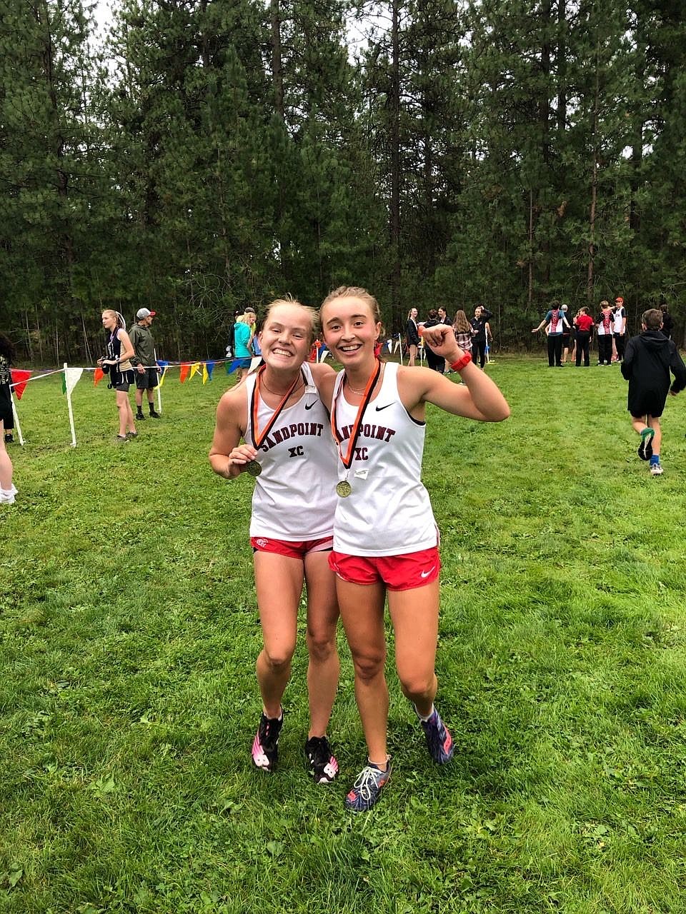 Lily Richardson, left, and Grace Rookey, right, pose with their medals after the conclusion of the Post Falls River Run on Thursday. Richardson finished in third place and Rookey finished in fifth in the junior/senior race.