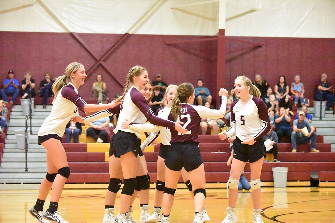 Members of the Troy Lady Trojans volleyball team celebrate a point against Noxon during the home opener on Aug. 31. (Scott Shindledecker/The Western News)