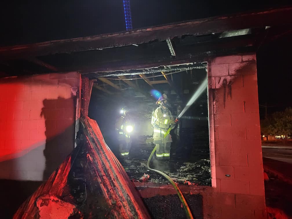 A firefighter hoses down the interior of the former Westside Pizza building in Quincy early Sunday morning.