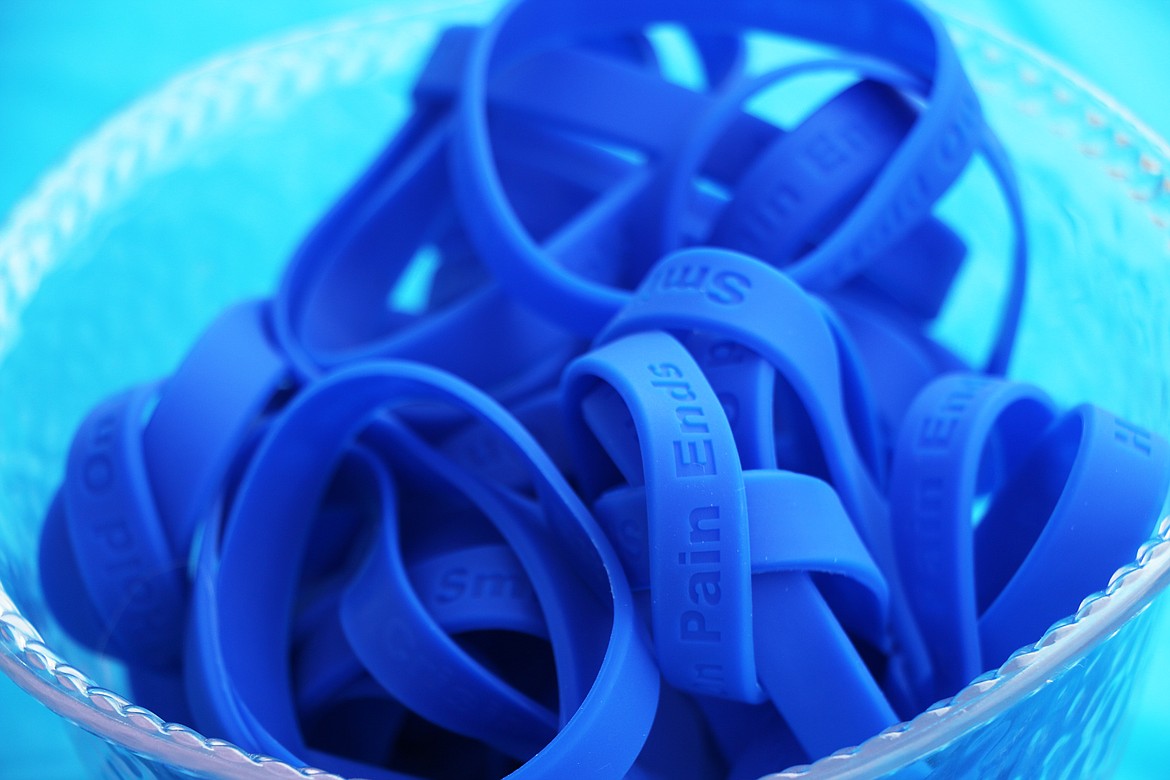 A bowl of bracelets handed out during the 2023 Walk for HOPE. On the outside, "smile" and "Hold On Pain Ends" are embossed. On the inside, a lifeline: "Crisis? Text 741-741" — the Suicide Prevention text line.