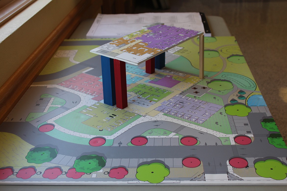 A mock-up of the new Quincy Valley Medical Center, blueprints in the background, on a table in the hospital boardroom. Construction of the real thing is scheduled to start in early October.