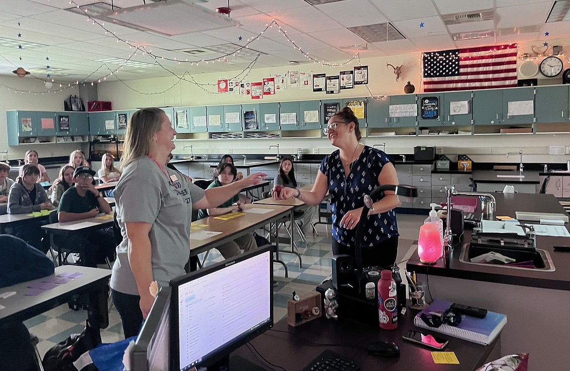 Trustee Heather Tenbrink, left, shares a smile with Lake City High School physical science teacher Tammy Wallace during an apple delivery Tuesday. Coeur d'Alene School District trustees have a long tradition of bringing apples to teachers on the first day of the new school year.
