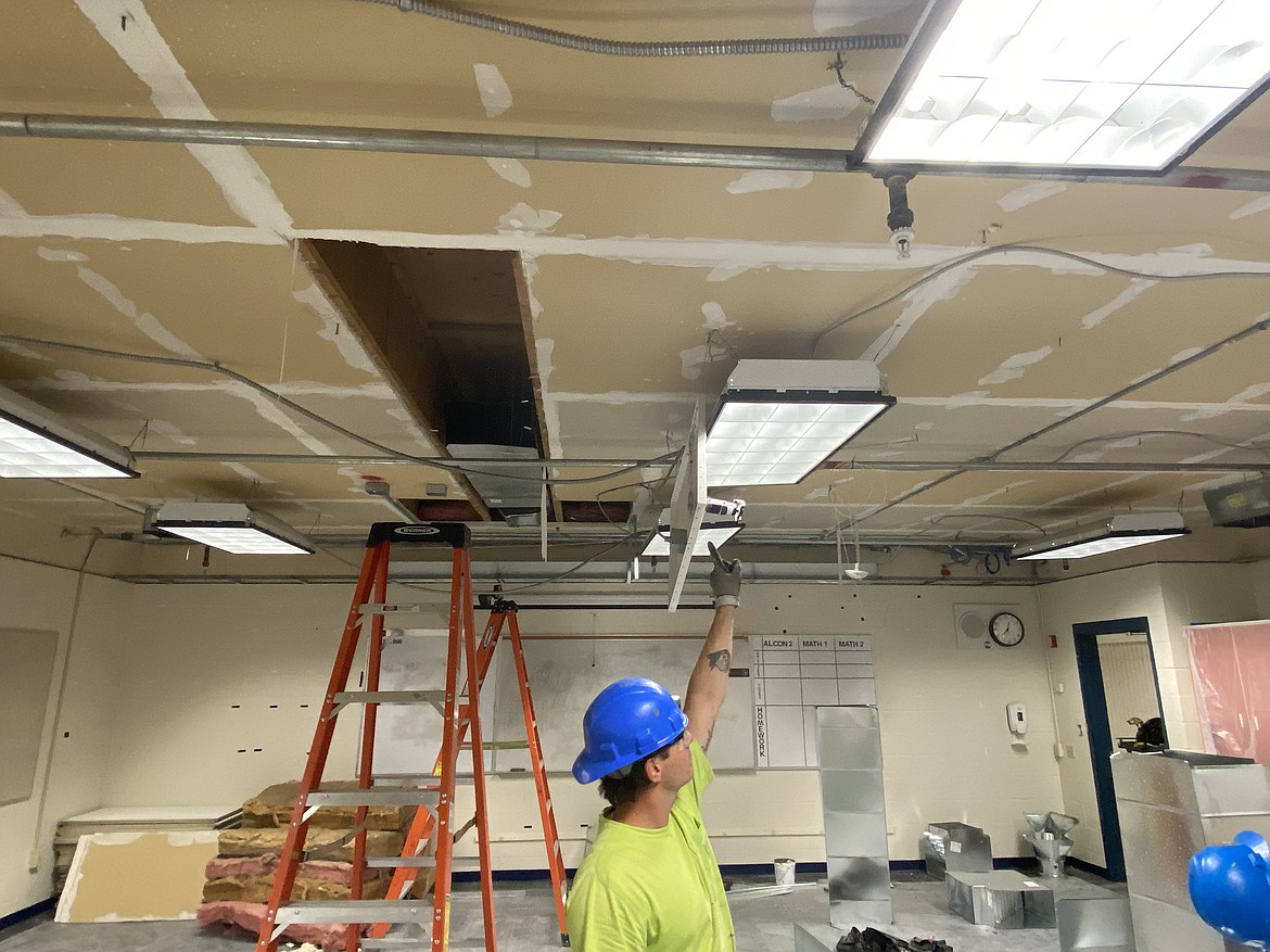 Charles Oxstien with Hurliman Heating and Air Conditioning points to a ceiling while working on the HVAC system at Coeur d'Alene High School over the summer.