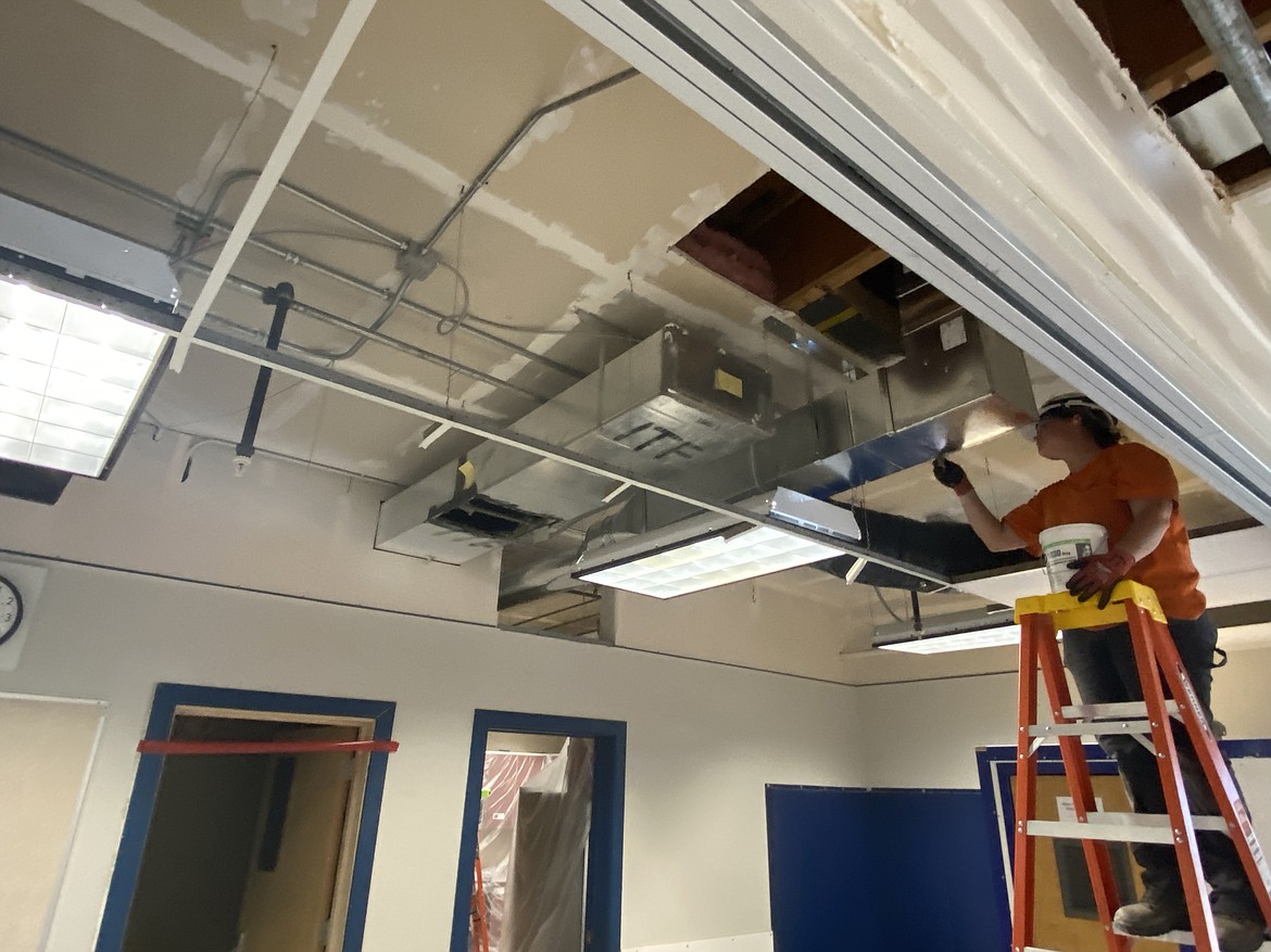 Subcontractor Hurliman Heating and Air Conditioning employee Andrea Putnam works on an air duct as she and other crews update Coeur d'Alene High School's heating, ventilation and air conditioning systems over the summer.