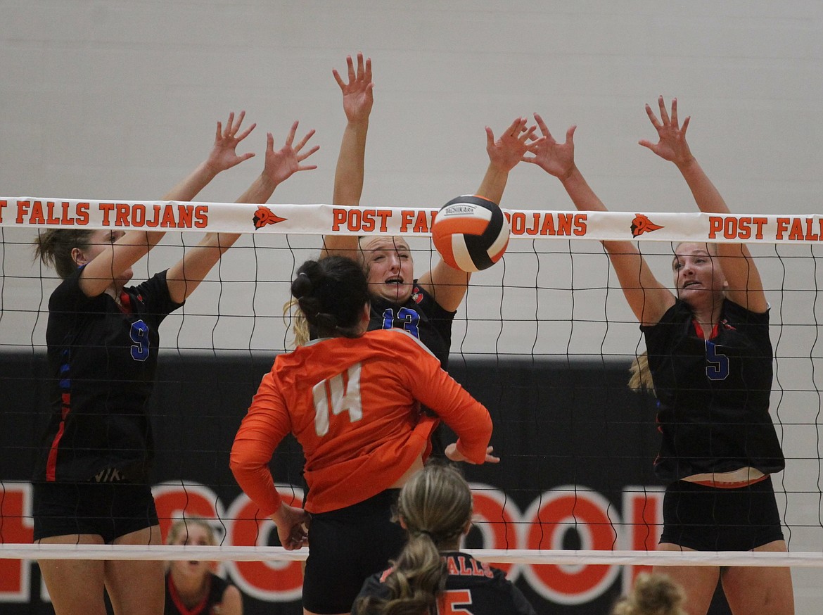 MARK NELKE/Press
Kiley Hart (9), Olivia Naccarato (13) and Paisley Goings (5) of Coeur d'Alene team up on the block against Kaela Gump of Post Falls on Tuesday night at The Arena.