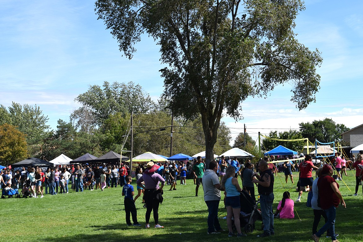 Lines form for food and families rest in the shade to watch volleyball in Volunteer Park during the afternoon festivities of Warden Community Days