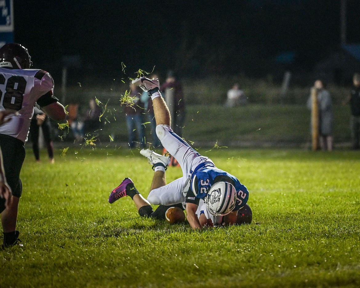 Grass flies as Milo Crooks takes down a Trojan during last Friday's Mission-Troy contest. (Photo by Christa Umphrey)