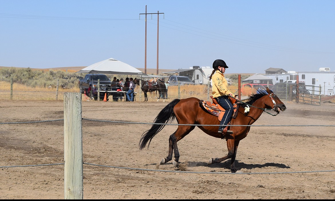 An Open Horse Show youth competitor riding Western-style takes her horse around the ring Saturday at the Wheat Land Communities Fair.