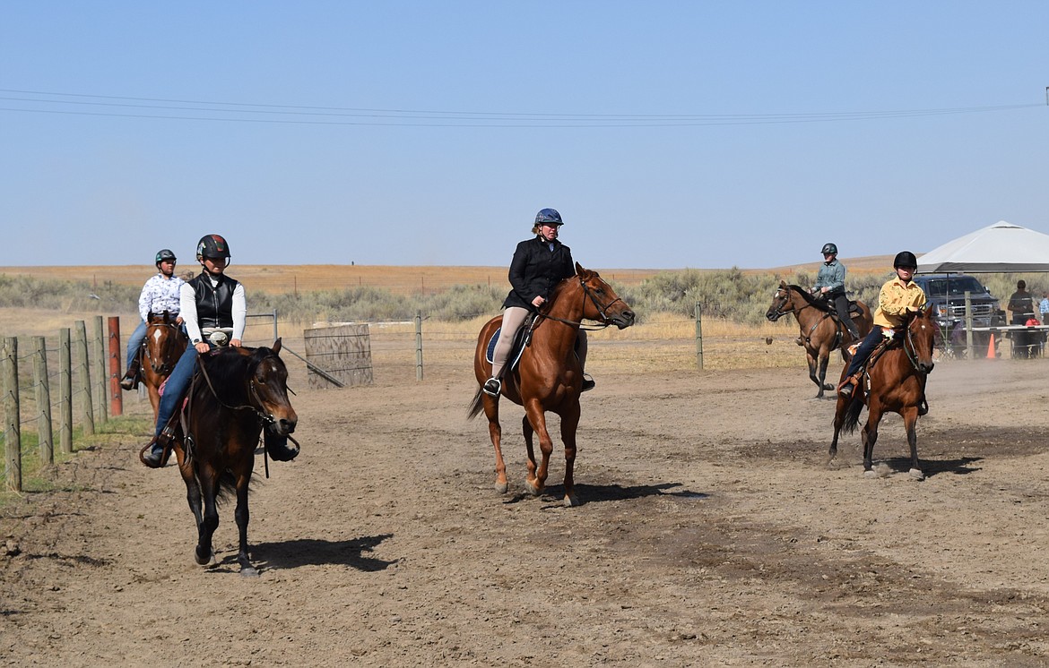 Several adult and youth competitors ride around the ring demonstrating their skill with their horses during the Open Horse Show on Saturday.