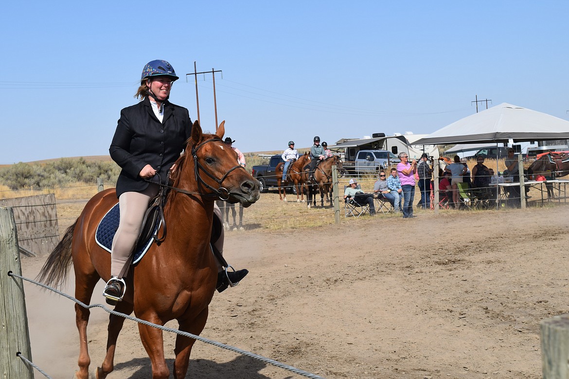 An adult competitor in Saturday’s Open Horse Show wears English-style riding gear during the competition as she rides her horse.