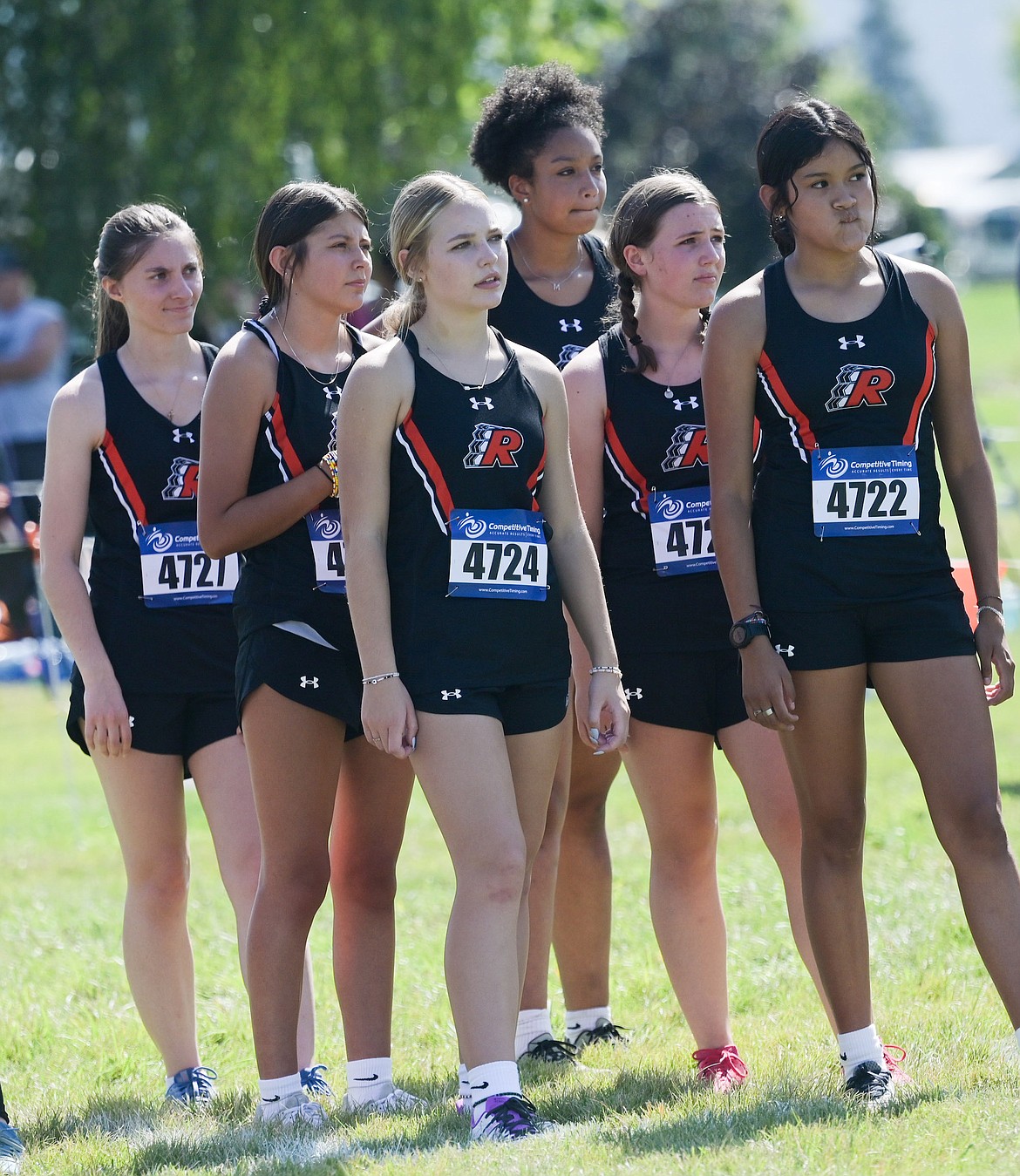 A group of Ronan runners waits on the field at Rebecca Farm during the Flathead Invitational. (Photo by Christa Umphrey)