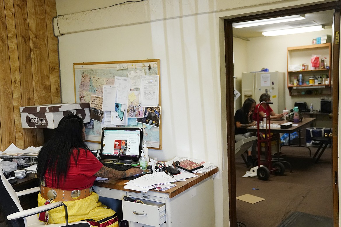 Grassroots advocate Reva Stewart, left, works at her desk as Geri Long and Coleen Chatter, right, answer phones at Drumbeat Indian Arts, Monday, July 31, 2023, in Phoenix. The women are trying to help find lost Native Americans who were left without a place to stay after the phony treatment centers in the Phoenix area abruptly shut down when Arizona cut off their Medicaid money amid investigations into widespread fraudulent billing. (AP Photo/Ross D. Franklin)