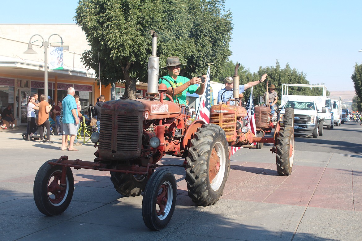 A tractor driver snaps a picture of the crowd at the 2022 Farmer Consumer Awareness Day parade.