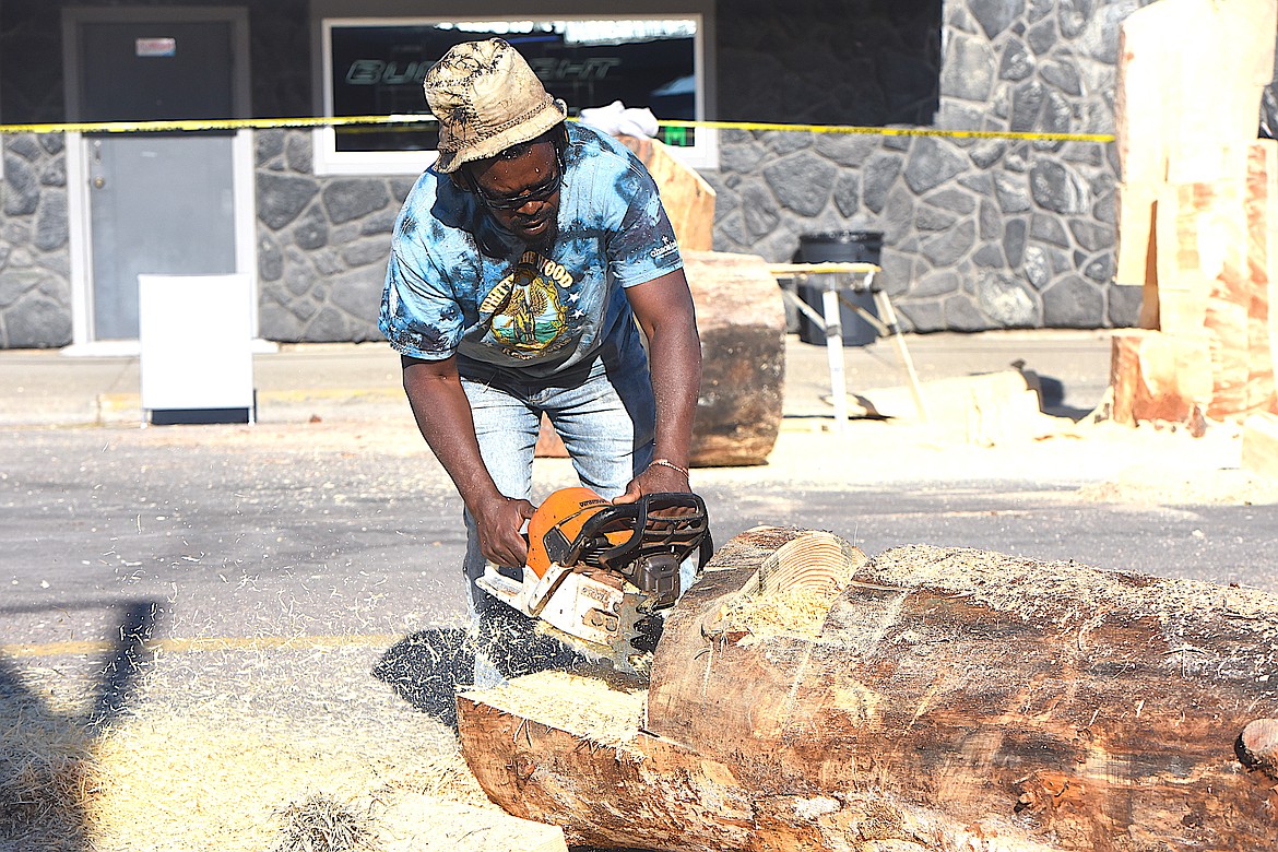 Zimbabwe's Bongo Love works on a piece of wood Thursday morning at the Kootenai Country Montana International Chainsaw Carving Championship on Mineral Avenue in Libby. (Hannah Chumley/The Western News)