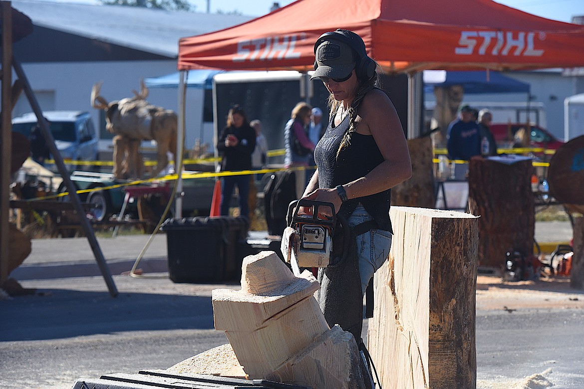 Canada's Brigitte Lochhead works on a piece of wood Thursday morning at the Kootenai Country Montana International Chainsaw Carving Championship on Mineral Avenue in Libby. (Hannah Chumley/The Western News)