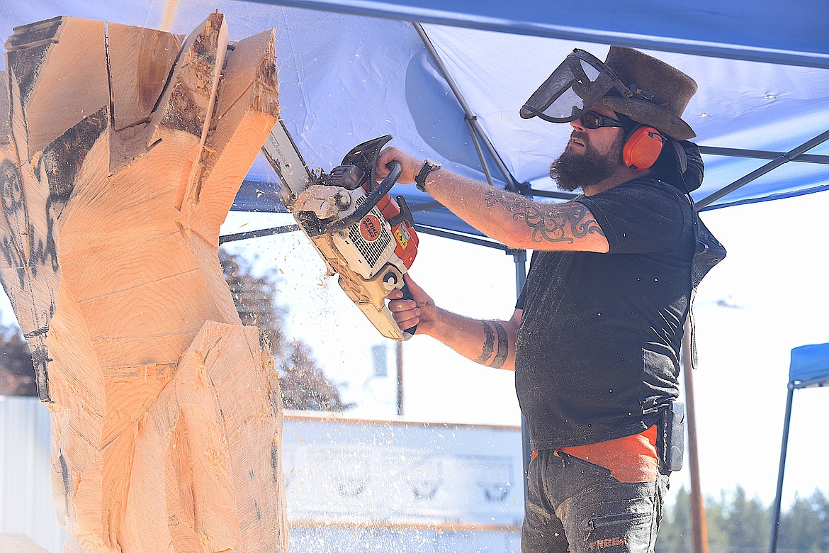 Whale's Chris Wood works on a piece of wood Thursday morning at the Kootenai Country Montana International Chainsaw Carving Championship on Mineral Avenue in Libby. (Hannah Chumley/The Western News)