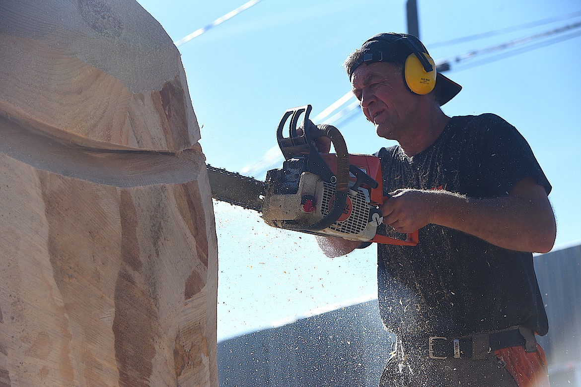 Lithuania's Raimondas Uzdravis works on a piece of wood Thursday morning at the Kootenai Country Montana International Chainsaw Carving Championship on Mineral Avenue in Libby. (Hannah Chumley/The Western News)