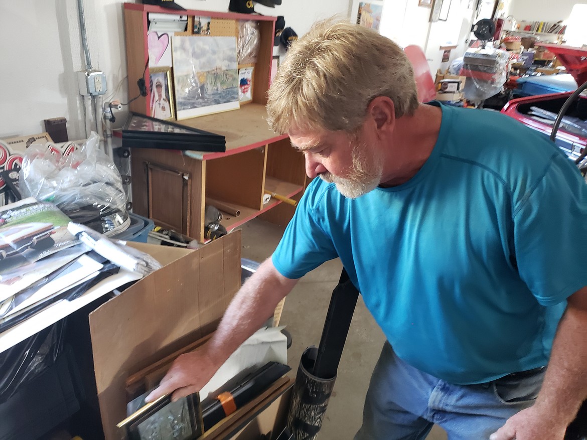 Rick Langlitz sifts through his late father's collection of tchotchkes, like empty picture frames from a wall memorial and tons of old Chevrolet parts.