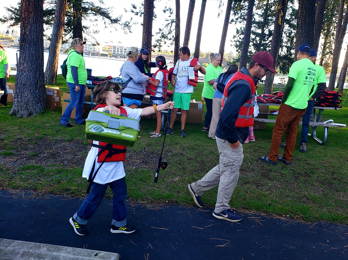 "I love fishing!" shouts Tanner Sams, running to catch up to his friend Luke Olsen, youth leader at Mountain View Church. Volunteers prepare tackle boxes, T-shirts and fishing poles for a day of fishing organized by  C.A.S.T. for Kids.