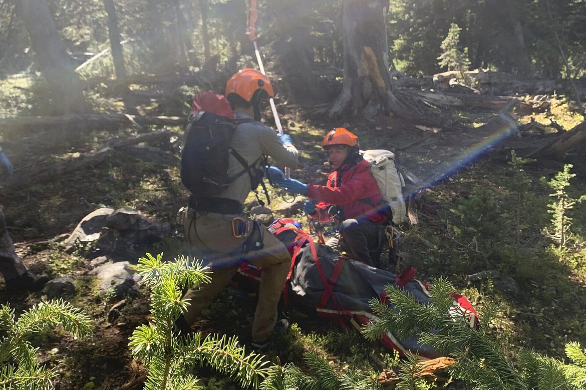 Sheriff Search and Rescue, members of the search and rescue team hook up rope hanging from a rescue helicopter to a basket holding Rudy Noorlander after Noorlander was mauled by a grizzly bear that bit off his lower jaw, Friday, Sept. 8, 2023. The attack happened in the Custer Gallatin National Forest about 55 miles north of Yellowstone National Park. Noorlander remained hospitalized, Monday, Sept. 11. His daughter said he's doing well, but is expected to be there through October for surgeries. (Gallatin County Sheriff Search and Rescue via AP)