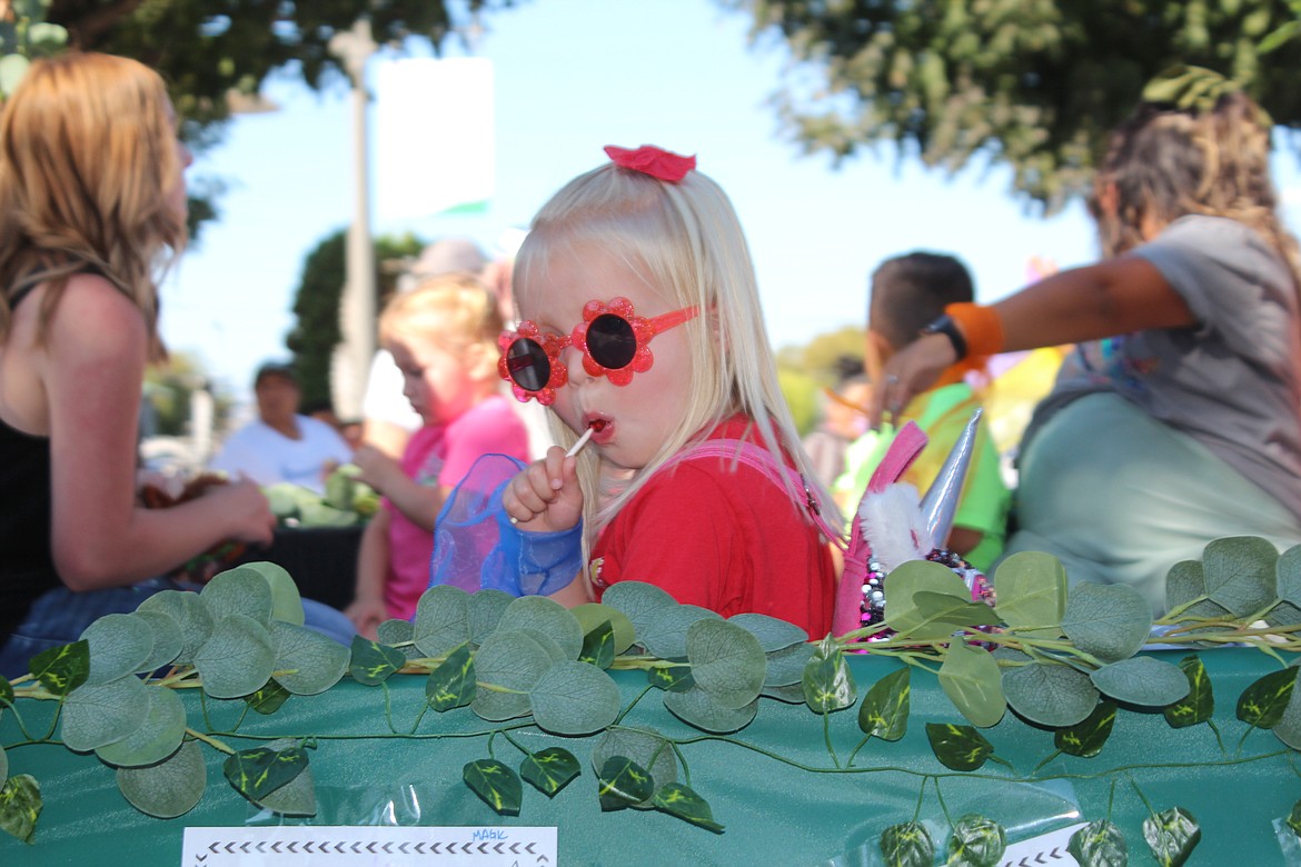 A participant enjoys a lollipop during the Farmer Consumer Awareness Day parade Saturday in Quincy.