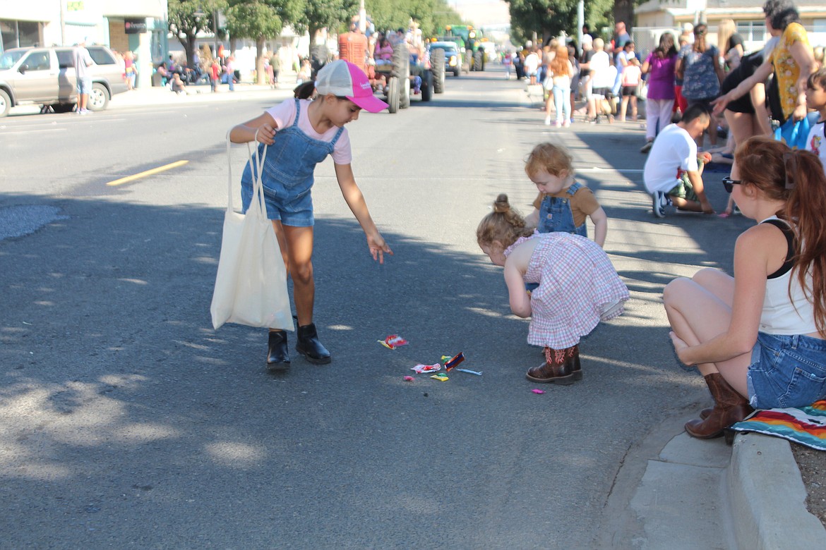 A Farmer Consumer Awareness Day parade participant leaves the candy in just the right place for some of the children on the route.