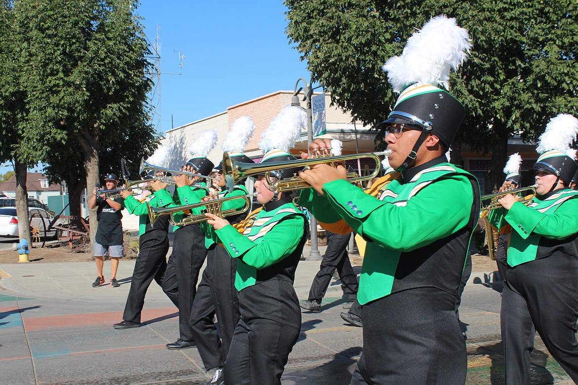 The Quincy High School marching band members show off their new uniforms during the Farmer Consumer Awareness Day parade Saturday.